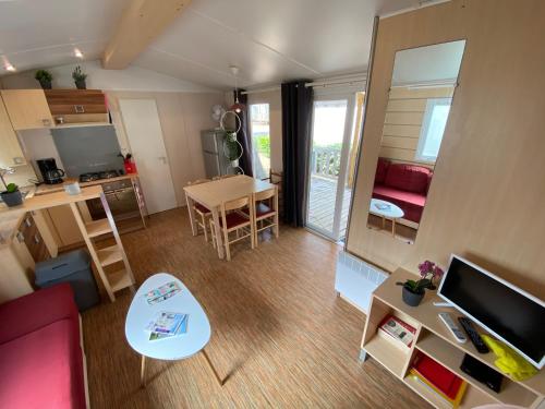 - un salon avec un canapé rouge et une table dans l'établissement Mon Coin de Vendée, à Saint-Jean-de-Monts