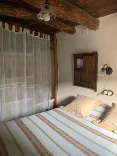 a bedroom with a bed with a curtain and a lamp at Caserío de Ovejuela in Ovejuela