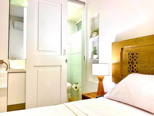 a bedroom with a bed and a white door at Casa Rambla Serra Cali in Cali