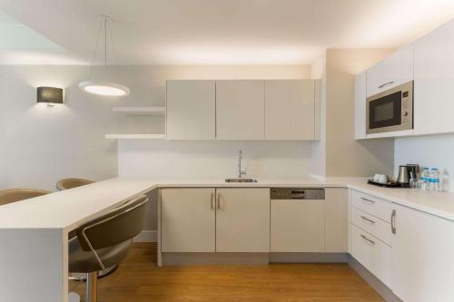 a kitchen with white cabinets and a counter top at Wyndham Grand Istanbul Europe in Istanbul