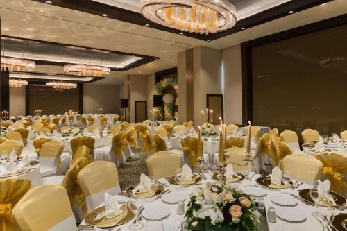 a banquet hall with white tables and yellow chairs at Wyndham Grand Istanbul Europe in Istanbul
