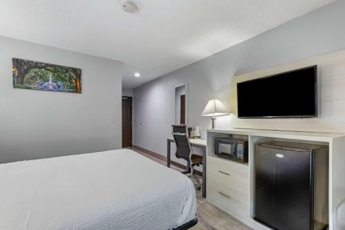a hotel room with a bed and a flat screen tv at Days Inn by Wyndham Savannah Gateway I-95 in Savannah
