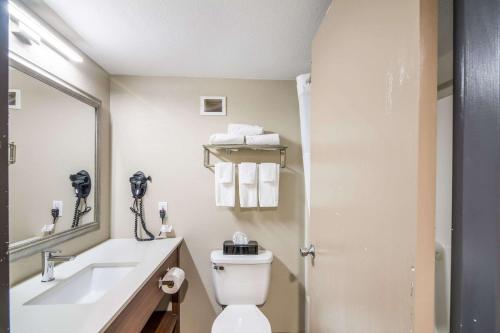 a bathroom with a toilet and a sink and a mirror at Quality Inn in Rochester