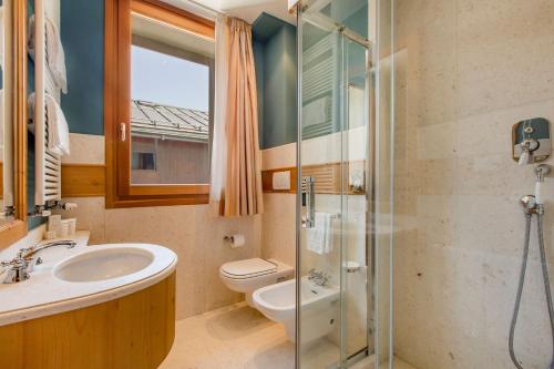 a bathroom with a sink and a toilet and a shower at Radisson Residences Savoia Palace Cortina d’Ampezzo in Cortina dʼAmpezzo