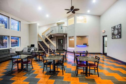 a room with tables and chairs and a staircase at Baymont by Wyndham Appleton in Appleton