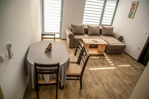 a living room with a table and a couch at Апартаменти ЗДРАВЕ in Sapareva Banya