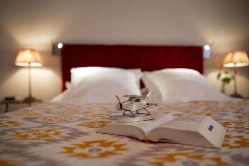 a book with a toy gun on top of it on a bed at Best Western Plus d'Europe et d'Angleterre in Mâcon