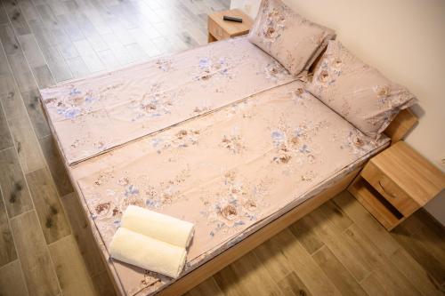 a bed in a room with pink sheets and pillows at Апартаменти ЗДРАВЕ in Sapareva Banya