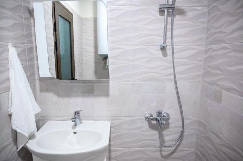 a white bathroom with a sink and a shower at Апартаменти ЗДРАВЕ in Sapareva Banya