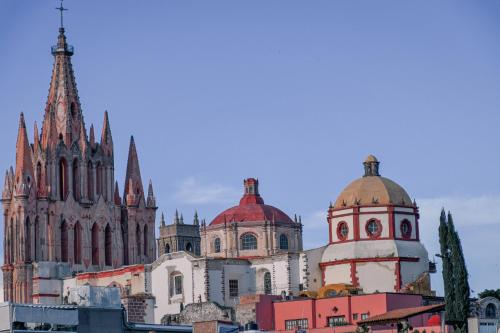 a group of buildings with a cathedral in the background at Casa Maricela B&B in San Miguel de Allende