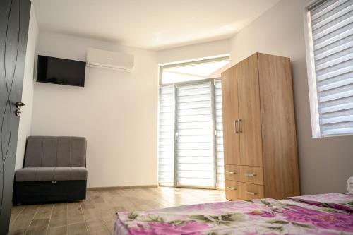 a bedroom with a bed and a chair and a window at Апартаменти ЗДРАВЕ in Sapareva Banya