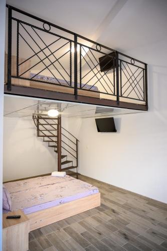 a loft with a bed in a room with a staircase at Апартаменти ЗДРАВЕ in Sapareva Banya