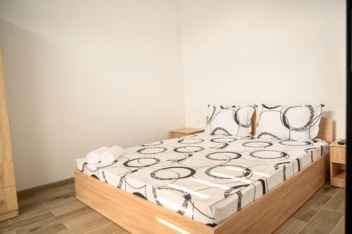 a bed with a white and black comforter at Апартаменти ЗДРАВЕ in Sapareva Banya