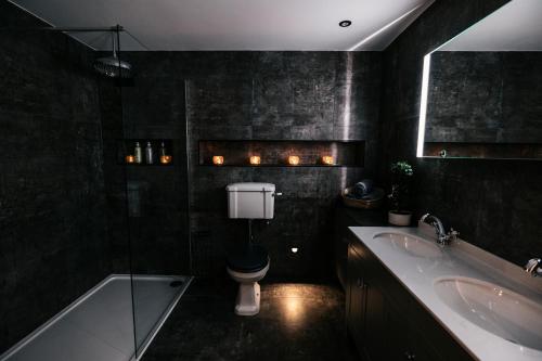a bathroom with a toilet and a sink and a tub at South Causey Inn in Stanley