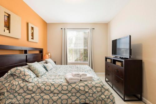 a bedroom with a bed and a flat screen tv at Spacious 2BR 2BA with Balcony 5 Mins to Convention Center & Epic Universe in Orlando