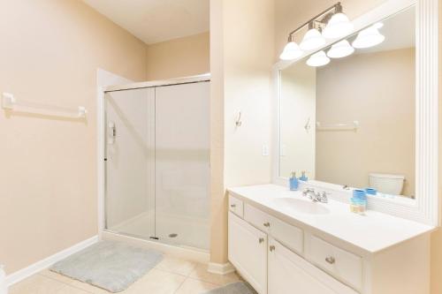 a white bathroom with a shower and a sink at Spacious 2BR 2BA with Balcony 5 Mins to Convention Center & Epic Universe in Orlando