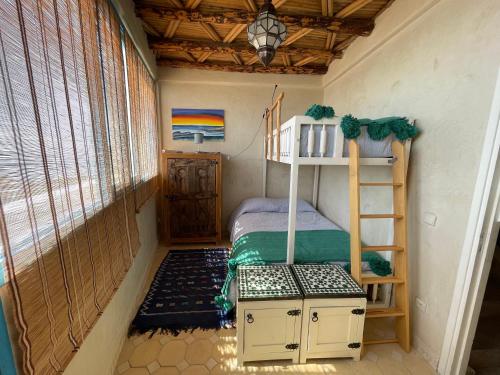 a small room with a bunk bed and a ladder at Taghazout Ocean View in Taghazout