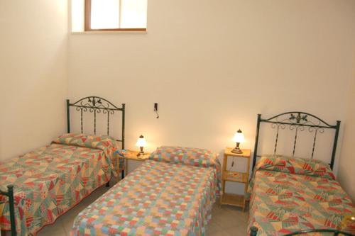 une chambre avec deux lits et deux tables et une fenêtre dans l'établissement Villa delle Agavi, à Campomarino
