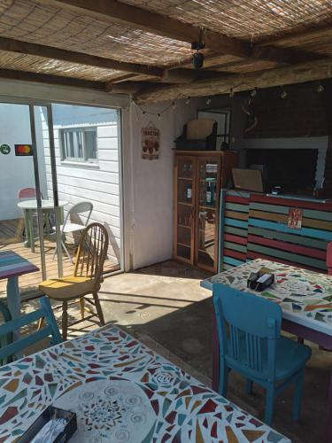 patio con mesa y sillas y cocina en "El Pelícano" Hostal, en Maldonado