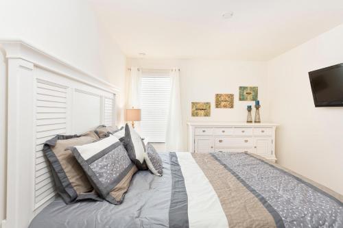 a bedroom with a bed and a tv on a wall at 3Br 3Bath Townhome BBQ Pool 15min Disney 1291ft in Kissimmee