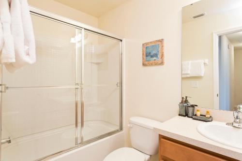 a bathroom with a shower and a toilet and a sink at 3Br 3Bath Townhome BBQ Pool 15min Disney 1291ft in Kissimmee