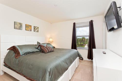 a bedroom with a bed and a tv and a window at 3Br 3Bath Townhome BBQ Pool 15min Disney 1291ft in Kissimmee