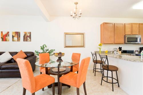 a kitchen and living room with a table and chairs at 3Br 3Bath Townhome BBQ Pool 15min Disney 1291ft in Kissimmee