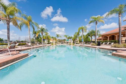 a large swimming pool with palm trees in a resort at 3Br 3Bath Townhome BBQ Pool 15min Disney 1291ft in Kissimmee