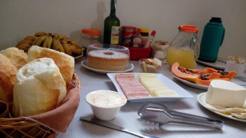 uma mesa com queijo e outros alimentos em Pousada Sol de Minas em Monte Sião