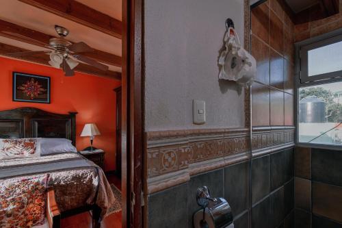 a bedroom with orange walls and a bed and a window at Casa Maricela B&B in San Miguel de Allende