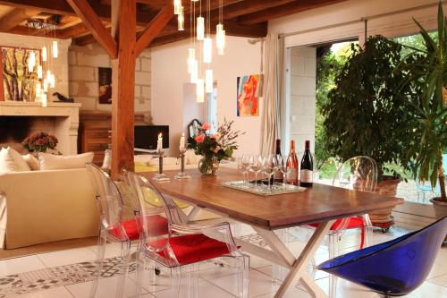 une salle à manger avec une table et des chaises en bois dans l'établissement Une Maison, Un Jardin, à Berthenay