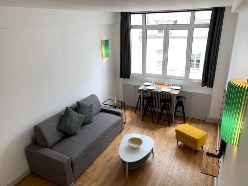 een woonkamer met een bank en een tafel bij Superbe appartement 4 Personnes au Centre de Paris in Parijs