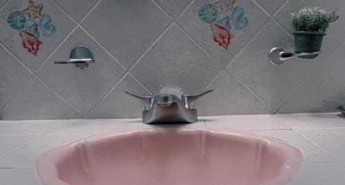 a pink sink in a bathroom with a faucet at Casa Maricela B&B in San Miguel de Allende