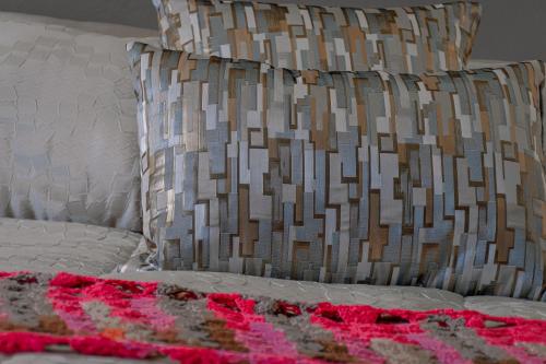 a bed with a white pillow and a brown and white pillows at Casa Maricela B&B in San Miguel de Allende