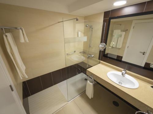 a bathroom with a sink and a glass shower at Hotel Lanzarote Village in Puerto del Carmen