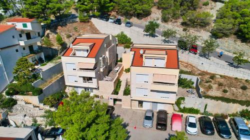 an overhead view of a building with cars parked in a parking lot at Apartments Villa Astra & Pinija in Brela