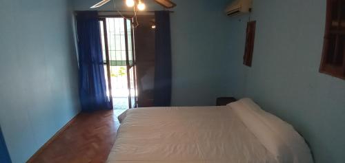 a bedroom with a white bed and a window at Hostal Carlos in Barraquero