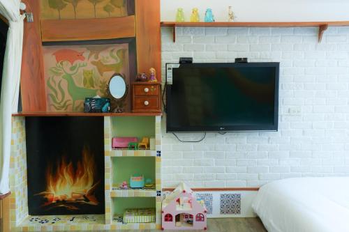 a bedroom with a tv and a fireplace at 耶伊親子溜滑梯民宿 in Tainan