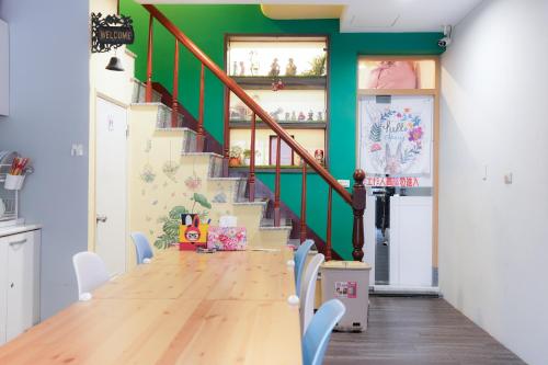 a dining room with a long table and a staircase at 耶伊親子溜滑梯民宿 in Tainan