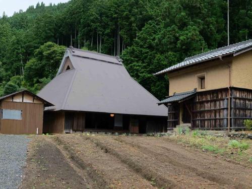 een gebouw met een grijs dak naast een onverharde weg bij Kasamatsutei - Vacation STAY 73449v in Shimizu