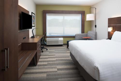 a hotel room with a bed and a desk and a television at Holiday Inn Express & Suites Ruston by IHG in Ruston