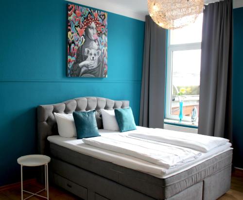 a bedroom with a large bed with a blue wall at Hotel Domstern in Cologne