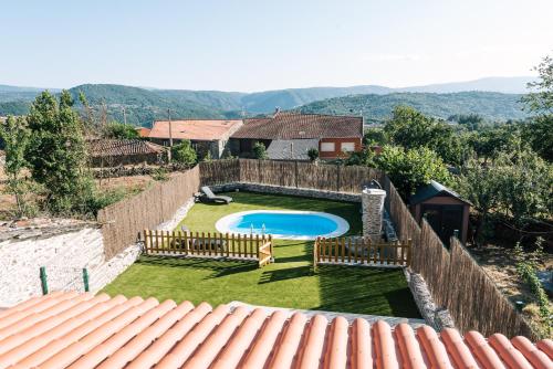 un patio trasero con piscina y valla en casa boral, en Doade