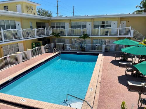 a pool in front of a hotel with tables and umbrellas at Beach Place Hotel in Miami Beach