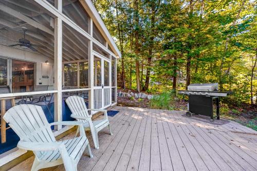 a porch of a house with two chairs and a grill at 20 Island Drive in Madison