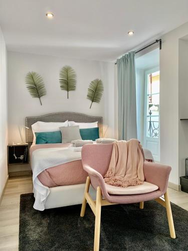a bedroom with a large bed and a chair at BF Suites & Apartments in Porto