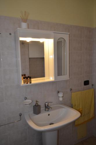 a bathroom with a white sink and a mirror at B&B Le Colonne in Montefusco