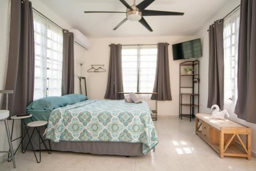 a bedroom with a bed and a ceiling fan at Senderos 4 a cozy studio 4 min from the beach in Rincon