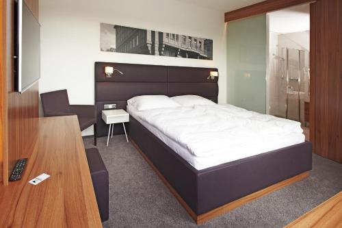 1 dormitorio con 1 cama grande y escritorio en Konference Park Hotel, en Hradec Králové