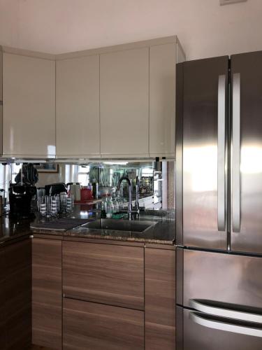 a kitchen with white cabinets and a stainless steel refrigerator at Skippers View Sunny Balcony in Eastbourne